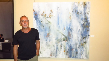 Jesús Mozos junto a una de sus obras en el Certamen de Pintura 2017 de Manzanares