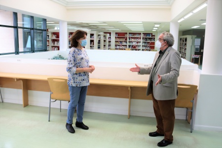 Candi Sevilla comprueba las medidas de distanciamiento en los puestos de estudio y lectura de la biblioteca junto a su directora