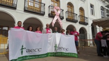 Autoridades y miembros de la AECC bajo el lazo rosa