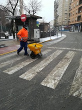 Un operario esparce sal en un paso de peatones en la zona del Gran Teatro