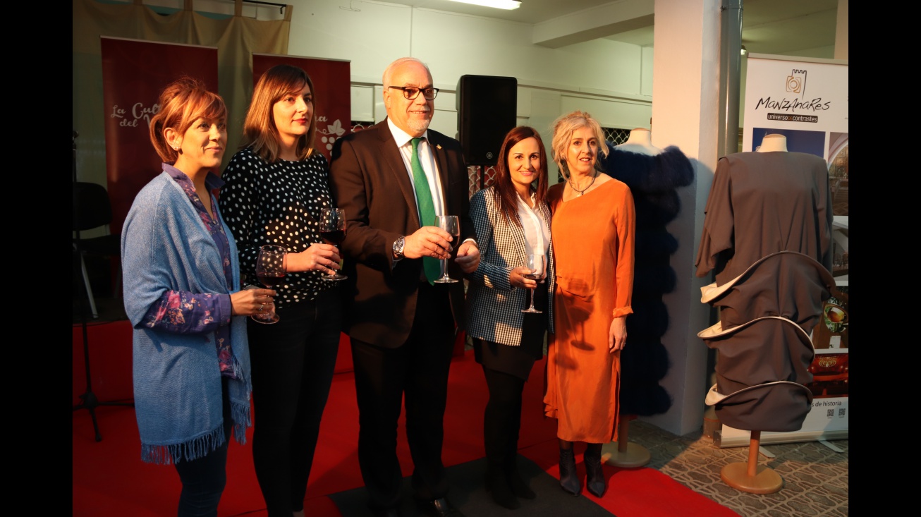 Autoridades y organizadora del desfile junto a los diseños de Manuel Piña