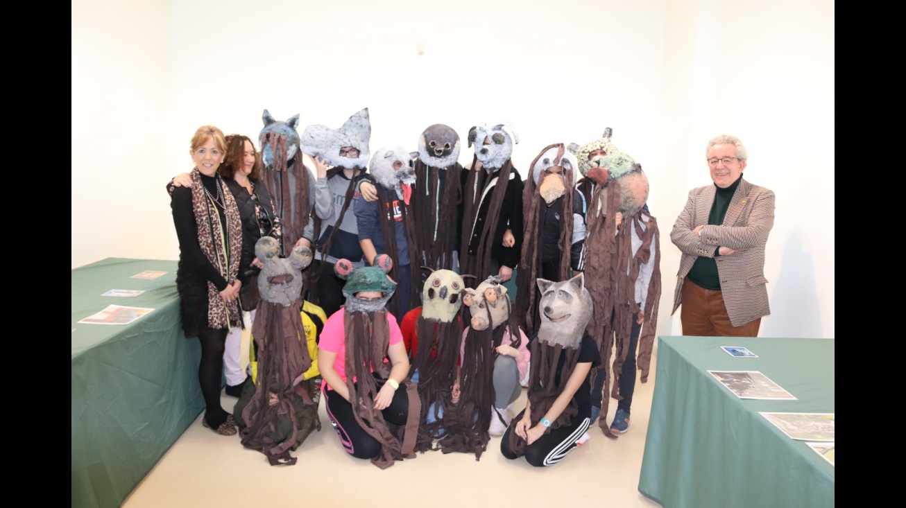 El alumnado posa con las máscaras de la exposición