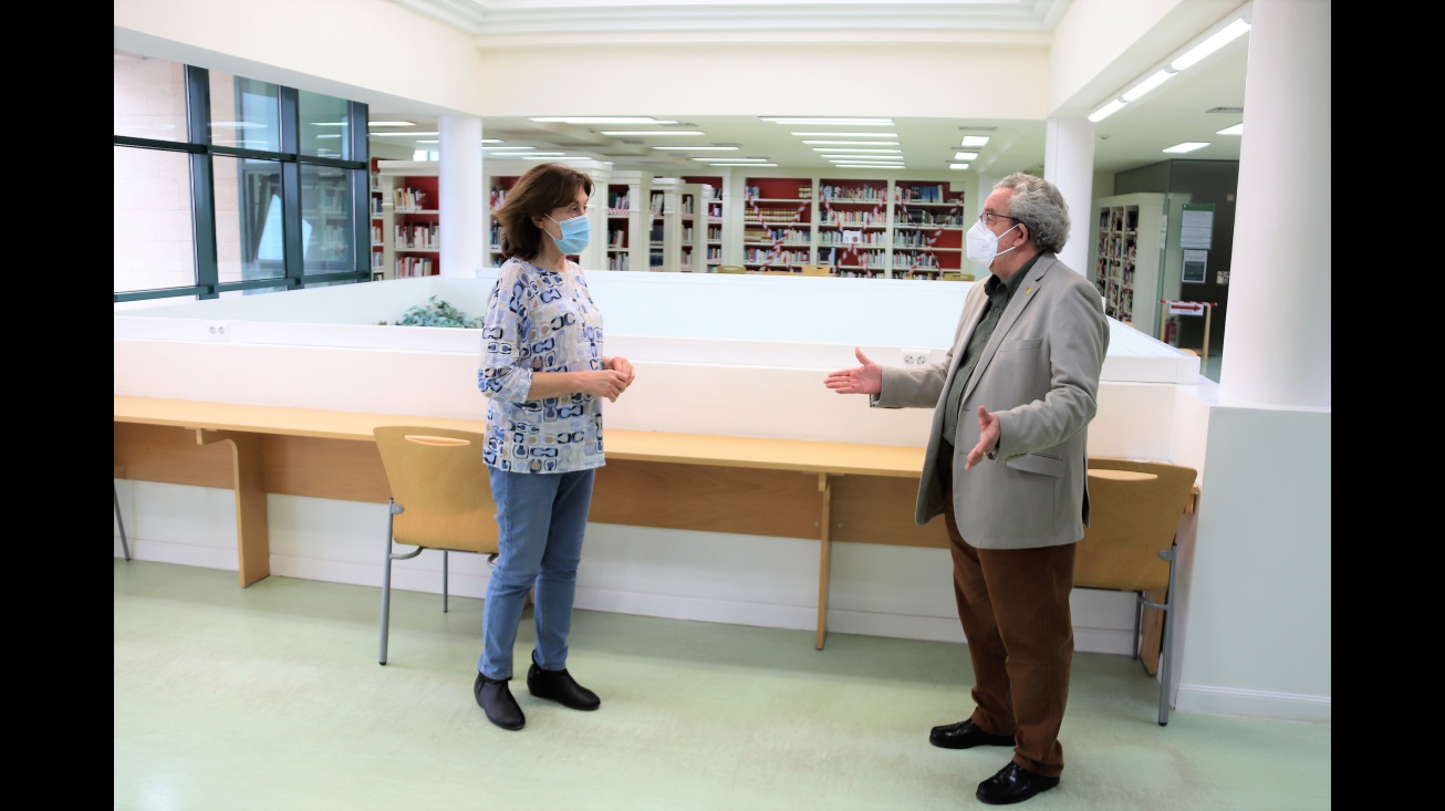 Candi Sevilla comprueba las medidas de distanciamiento en los puestos de estudio y lectura de la biblioteca junto a su directora