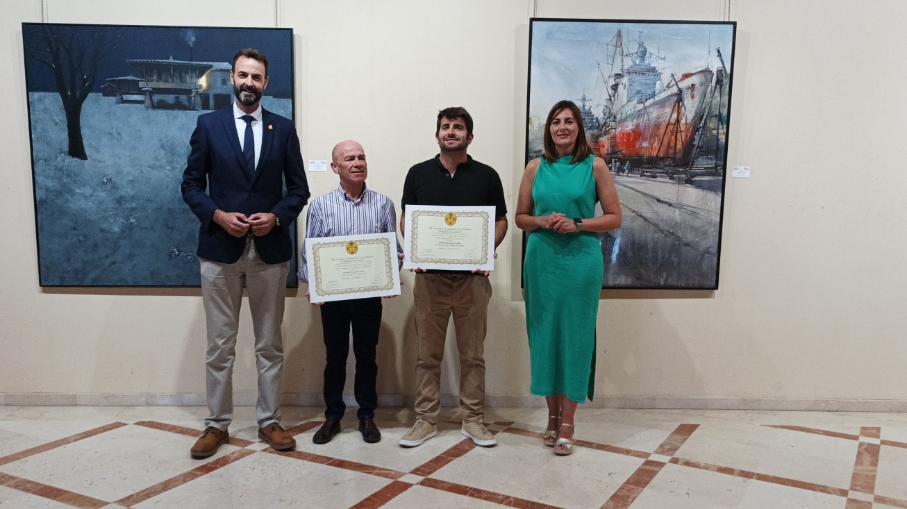 Autoridades con dos de los premiados y sus obras